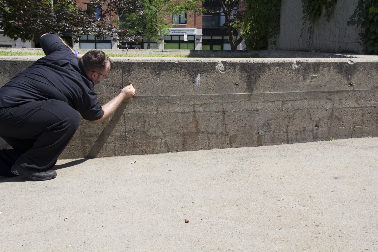 Steve Giasson. Performance invisible n° 9 (Insérer discrètement des bijoux dorés dans l'Agora de Charles Daudelin (Square Viger, Montréal).)) Performeur : Steve Giasson. Crédit photographique : Daniel Roy. 1er août 2015.
In "Actes de disparition", Square Viger, Montréal.