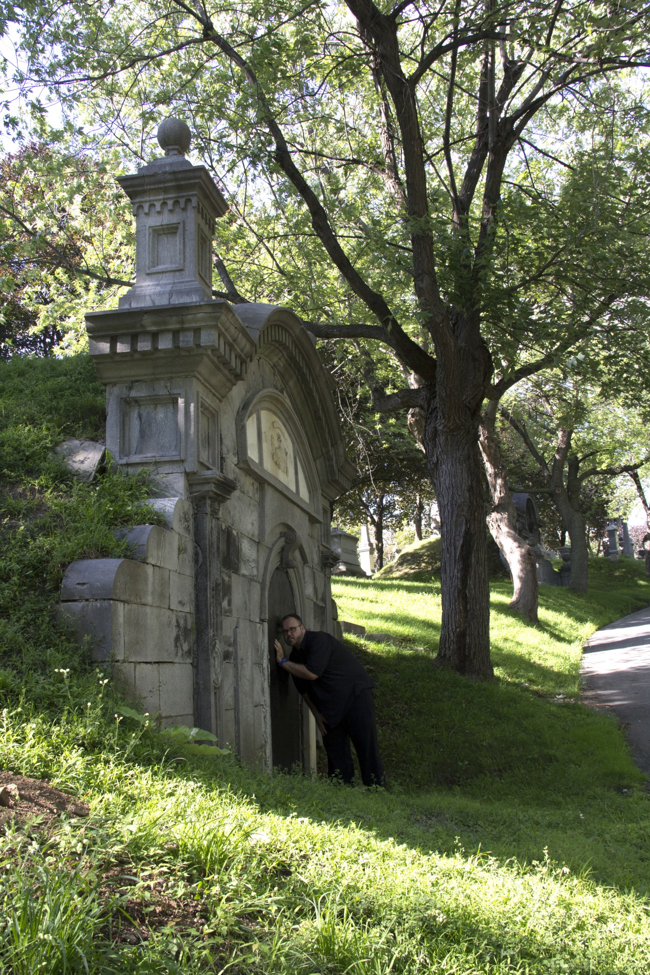 Steve Giasson. Performance invisible n° 13 (Écouter aux portes). Caveau de la famille Doutre-Dandurand, cimetière Notre-Dame-des-Neiges, Montréal. Performeur : Steve Giasson. Crédit photographique : Daniel Roy. 1er août 2015.