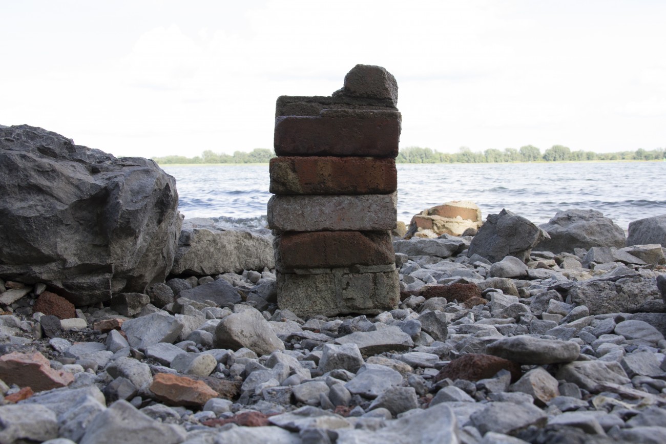 Steve Giasson. Performance invisible n° 16 (Poser des briques par-dessus d'autres briques). Performeur : Steve Giasson. Crédit photographique : Daniel Roy. 8 août 2015.