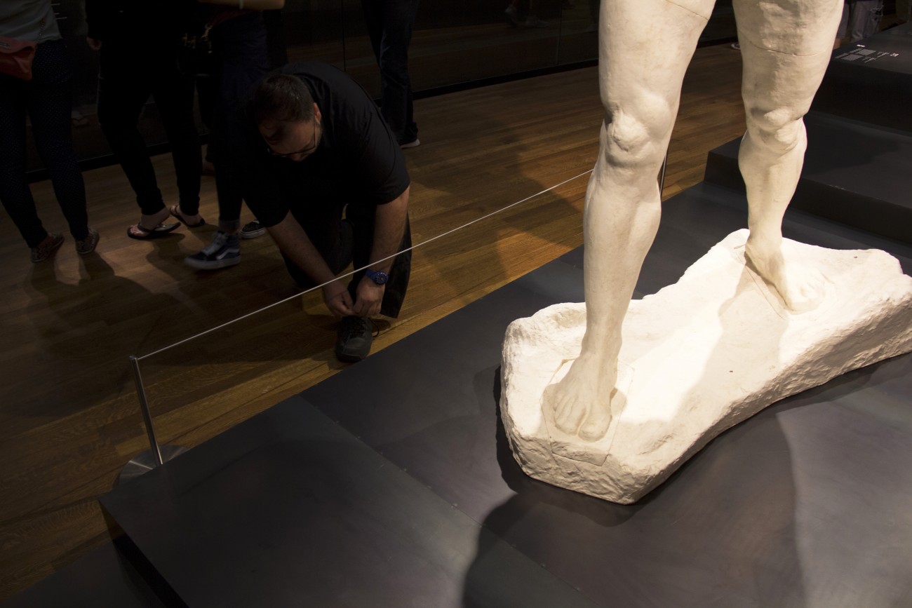 Steve Giasson. Performance invisible n° 35 (Rattacher les lacets de ses chaussures au milieu d’une foule). Auguste Rodin. L'Homme qui marche. 1907. Musée des beaux-arts de Montréal. Performeur : Steve Giasson. Crédit photographique : Daniel Roy. 29 août 2015.
L'Homme qui marche