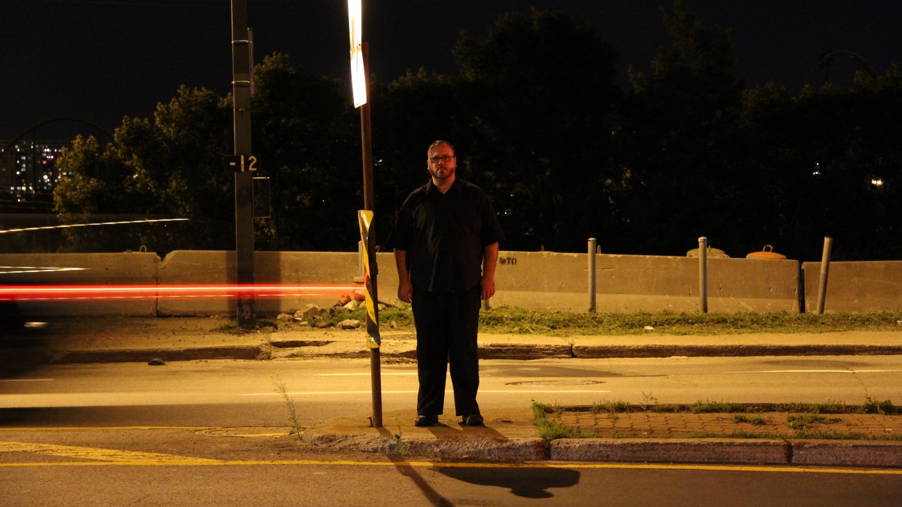 Steve Giasson. Performance invisible n° 3 (Demeurer immobile et en silence (un certain temps).) Performeur : Steve Giasson. Participant involontaire : Inspecteur de police. Crédit photographique : Daniel Roy. 17 juin 2015.