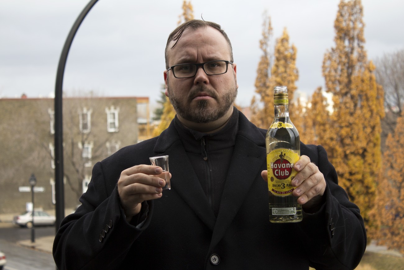 Steve Giasson. Performance invisible n° 46 (Boire du rhum blanc sous la pluie). Performeur : Steve Giasson. Crédit photographique : Martin Vinette. 11 novembre 2015.