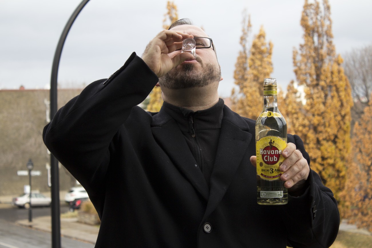 Steve Giasson. Performance invisible n° 46 (Boire du rhum blanc sous la pluie). Performeur : Steve Giasson. Crédit photographique : Martin Vinette. 11 novembre 2015.