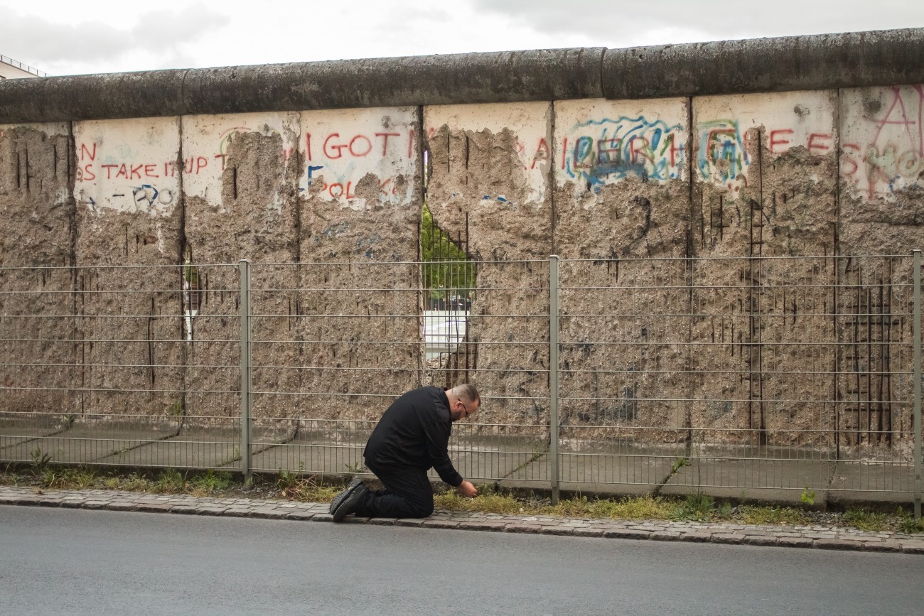 Steve Giasson. Performance invisible n° 115 (Arracher l'herbe (afin qu'elle reste verte)). Performeur : Steve Giasson. Crédit photographique : Martin Vinette. Mur de Berlin, Topographie des Terrors, Berlin. 14 mai 2016.