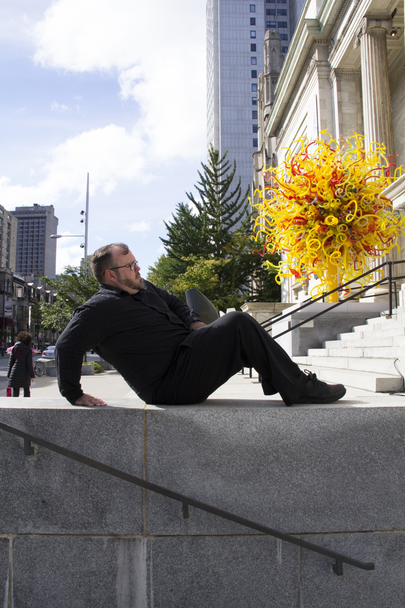 Steve Giasson. Performance invisible n° 37 (Adopter, pendant un certain temps, une posture évoquant la sculpture Reclining Figure (1969-70) d’Henry Moore.) Dale Chihuly. 2003. Le soleil, de la série « Lustres & Tours ». Henry Moore. 1968. Grande tête totémique. Musée des beaux-arts de Montréal. D'après Bruce McLean. Pose Work for Plinths. 1971. Performeur : Steve Giasson. Crédit photographique : Daniel Roy. 3 octobre 2015.