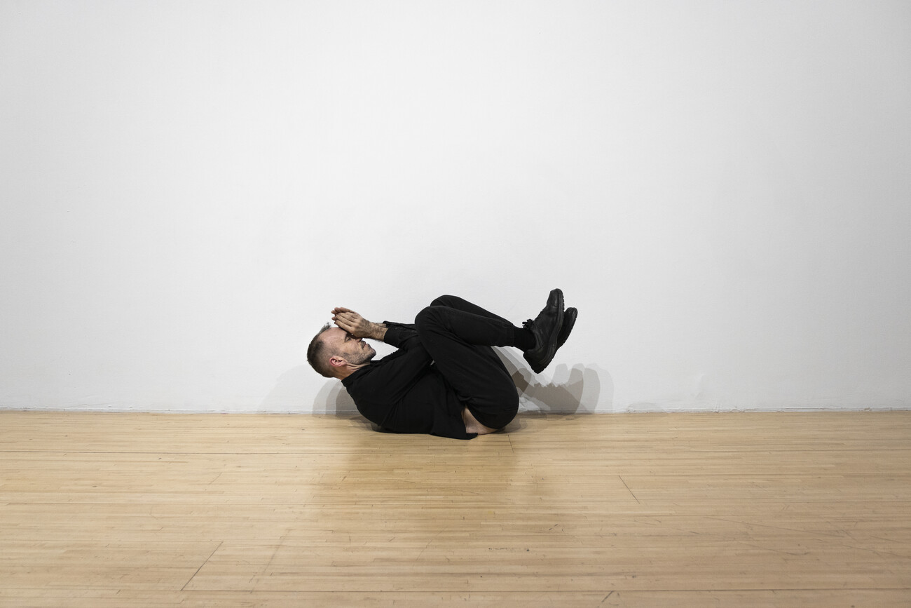 Steve Giasson. Performance invisible n&deg; 171 (Raser le sol). D'apr&egrave;s Bruce Nauman. Wall/Floor Positions. 1968. D'apr&egrave;s Bruce Nauman. Tony Sinking into the Floor, Face Up and Face Down. 1973. D'apr&egrave;s Bruce Nauman. Elke Allowing the Floor to Rise Up over Her, Face Up. 1973. D'apr&egrave;s Dan Graham. Roll, 1970. Reenactment de Tino Sehgal. Instead of allowing some thing to rise up to your face dancing bruce and dan and other things. 2000. Performeur : Steve Giasson. Cr&eacute;dit photographique : Martin Vinette. Retouches photographiques : Daniel Roy. AXEN&Eacute;O7, Gatineau. 5 novembre 2019.